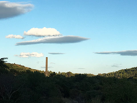 Factory chimney in La Caunette, with silver clouds. Photo by Giles Mitchell.